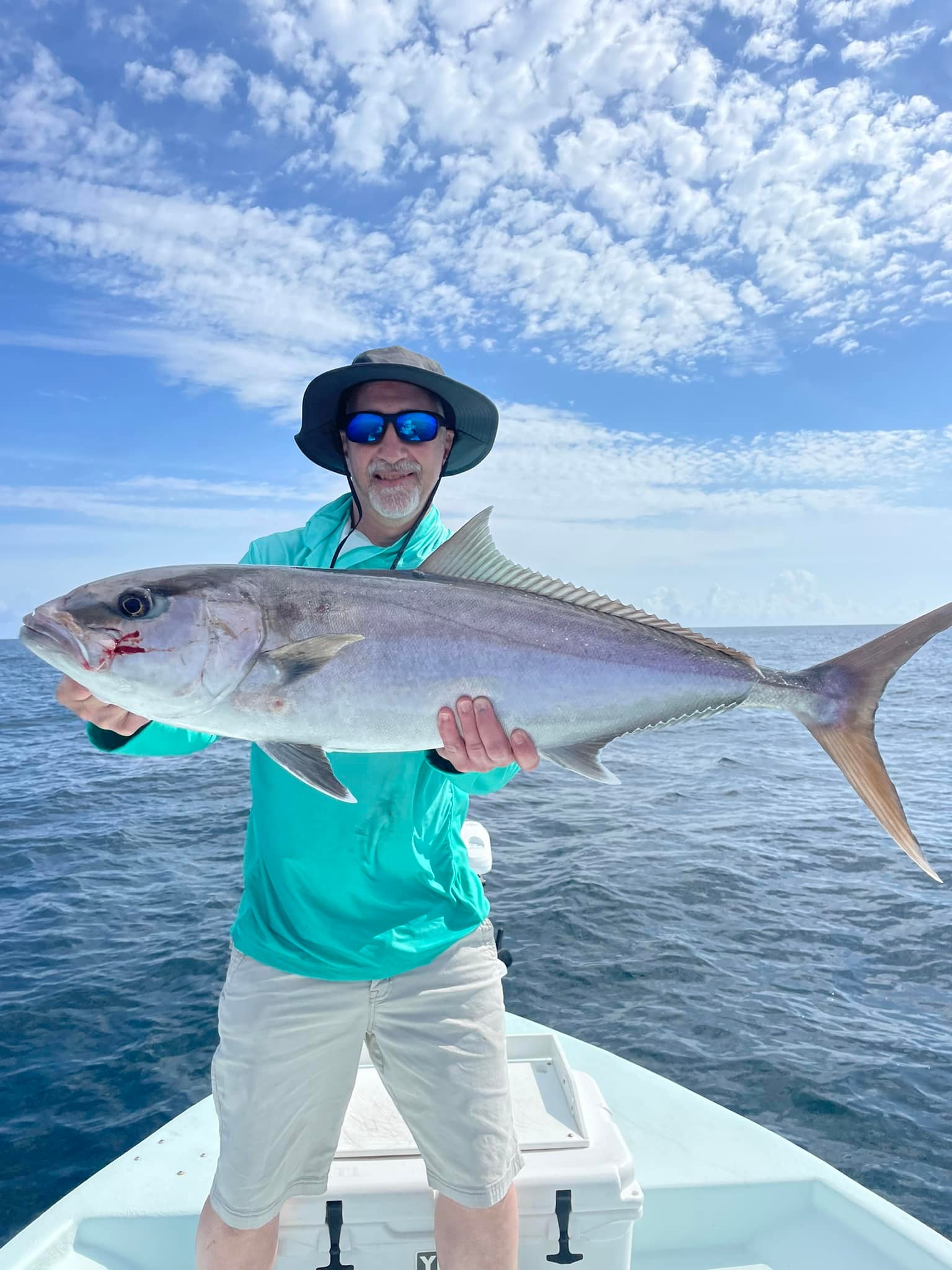 A diver holds a large greater amberjack fish at Pensacola Beach