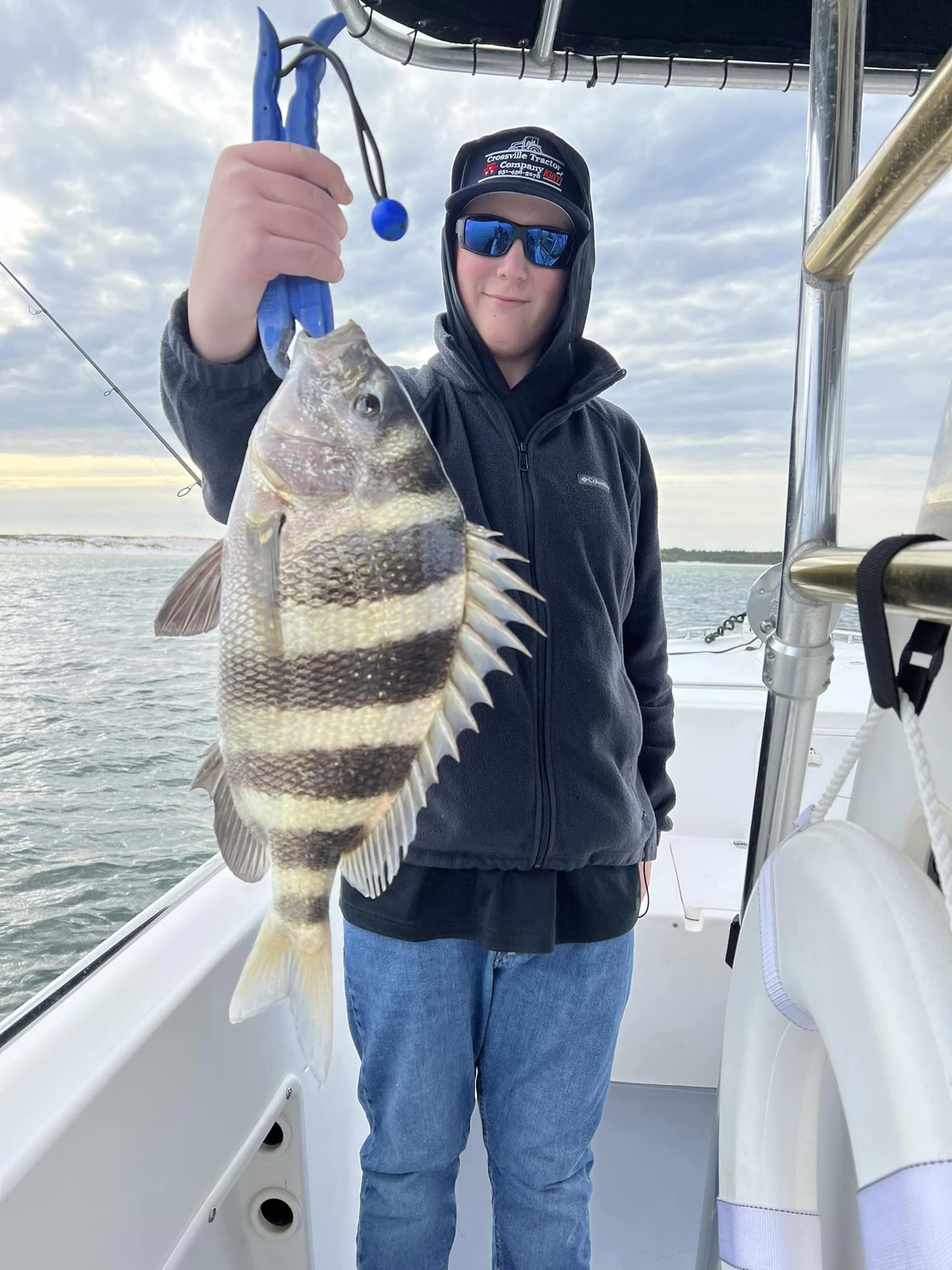 A fisherman holding a large sheepshead fish caught at Pensacola Beach.