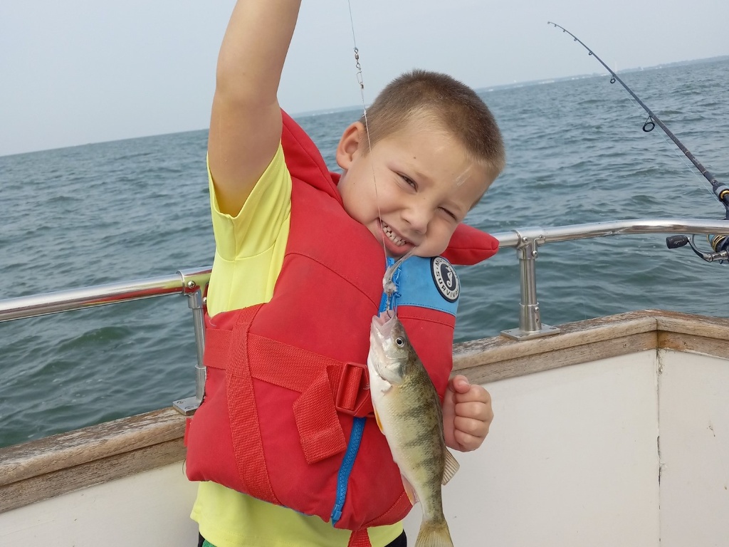 An angler holds an American Yellow Perch, a freshwater fish, at Lakeside Marblehead