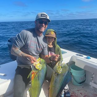 Two fishermen holding their catch in San Diego