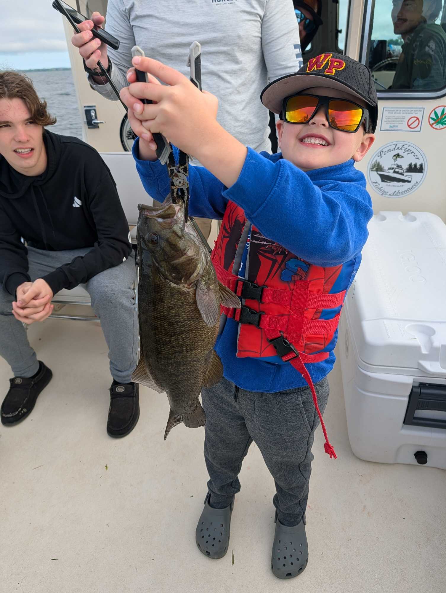 Smallmouth bass caught while fishing in Henderson NY displayed on boat deck
