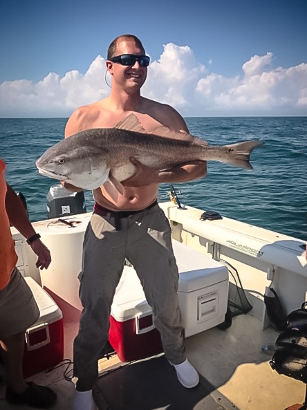 Angler holding a 28-inch fish at Surfside Beach