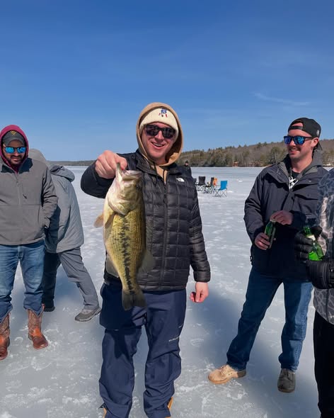 Ice fishing scene showing caught bass on frozen lake in Poland, Maine