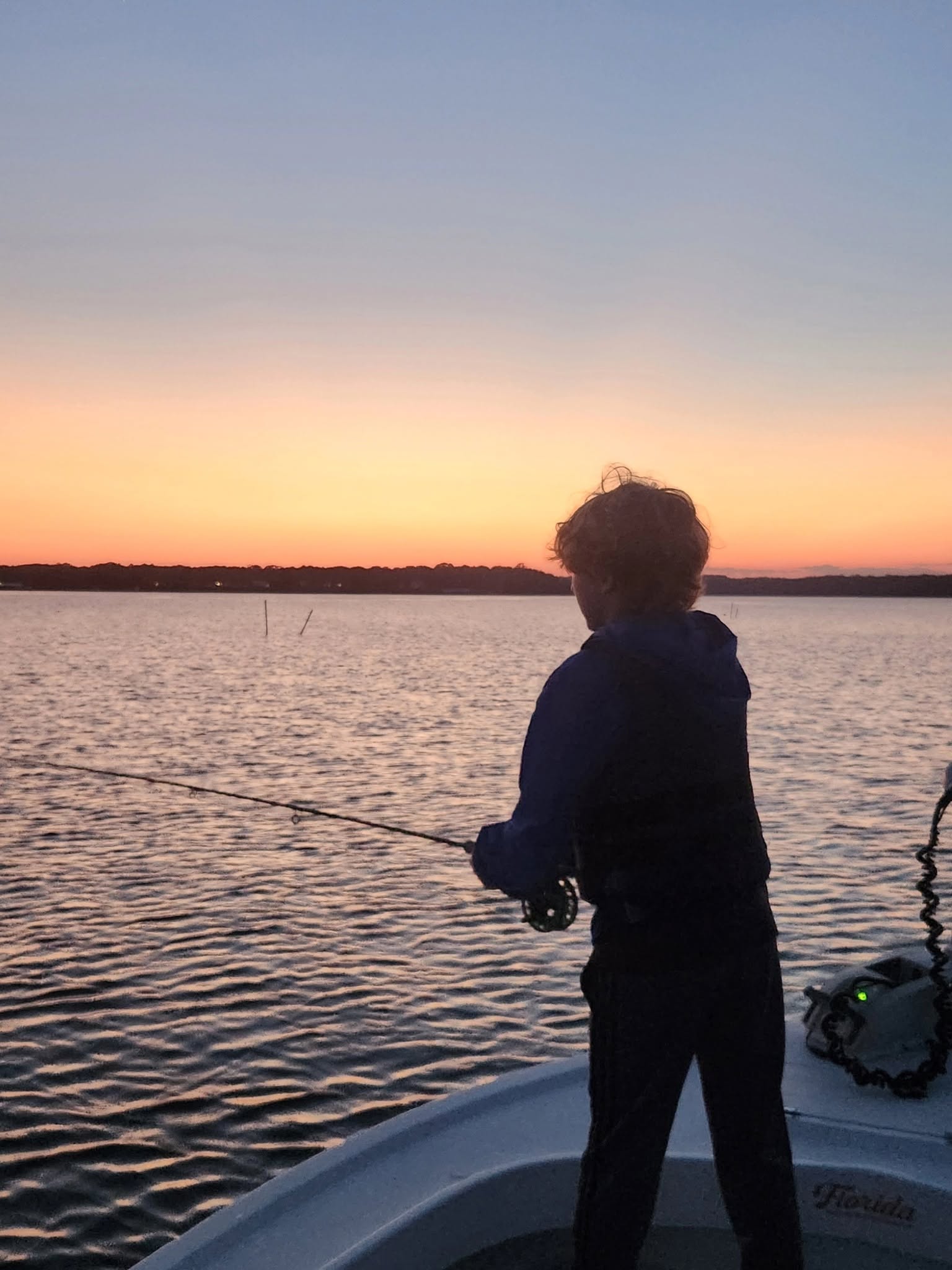 Fishing from boat at sunset on calm water in Reedville VA