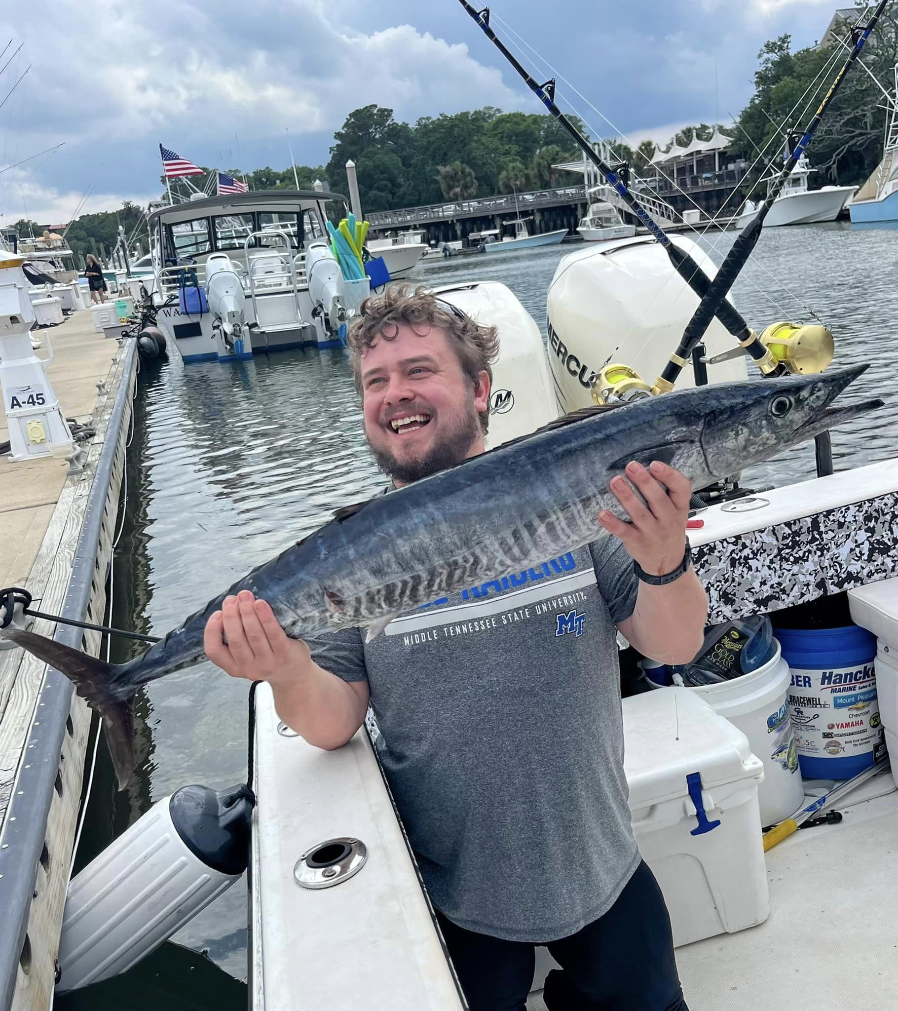 A fisherman proudly holding a 34-inch wahoo fish caught in SC