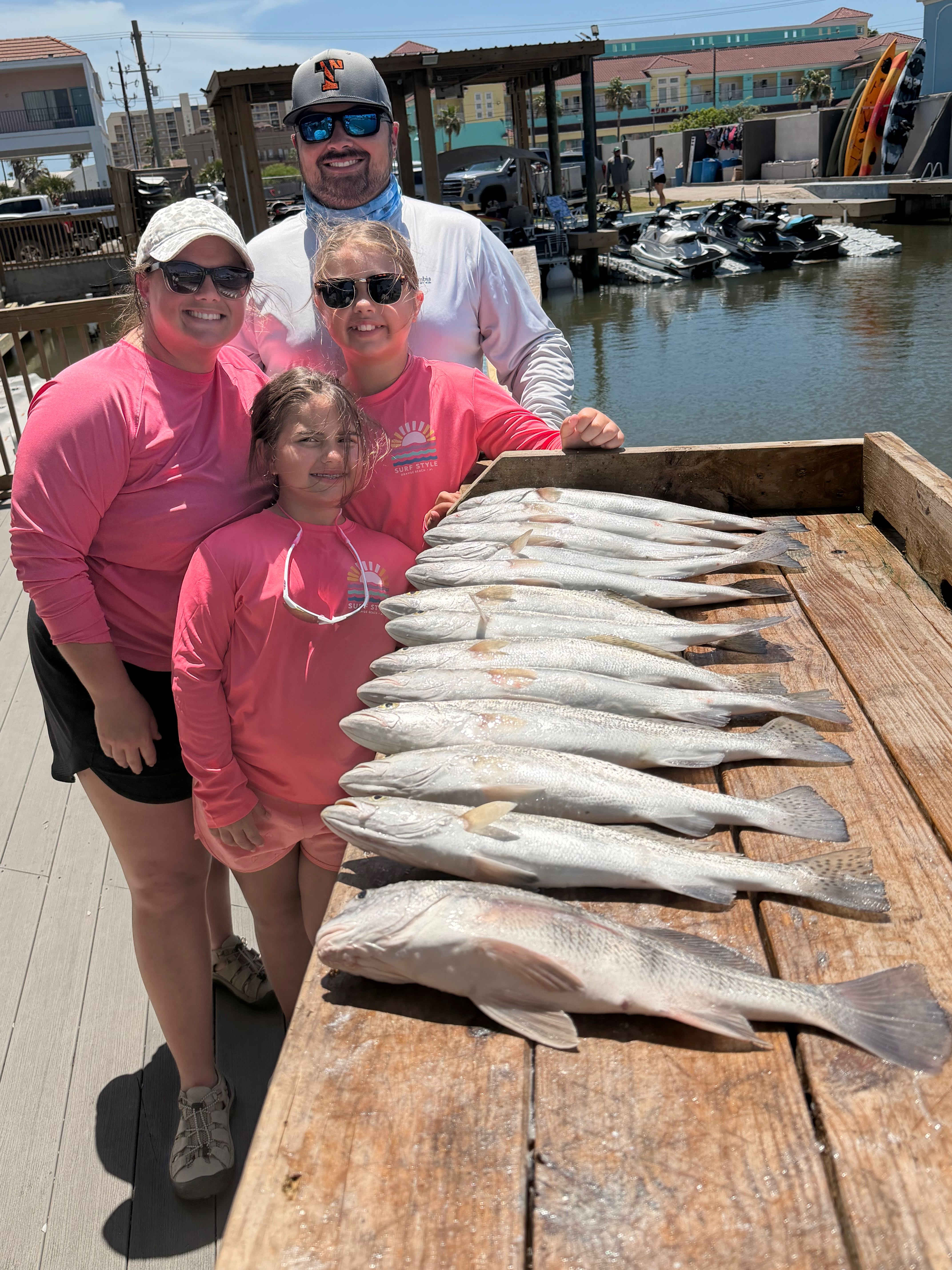 Family fishing trip catch of black drum and other fish species displayed on wooden dock at South Padre Island TX