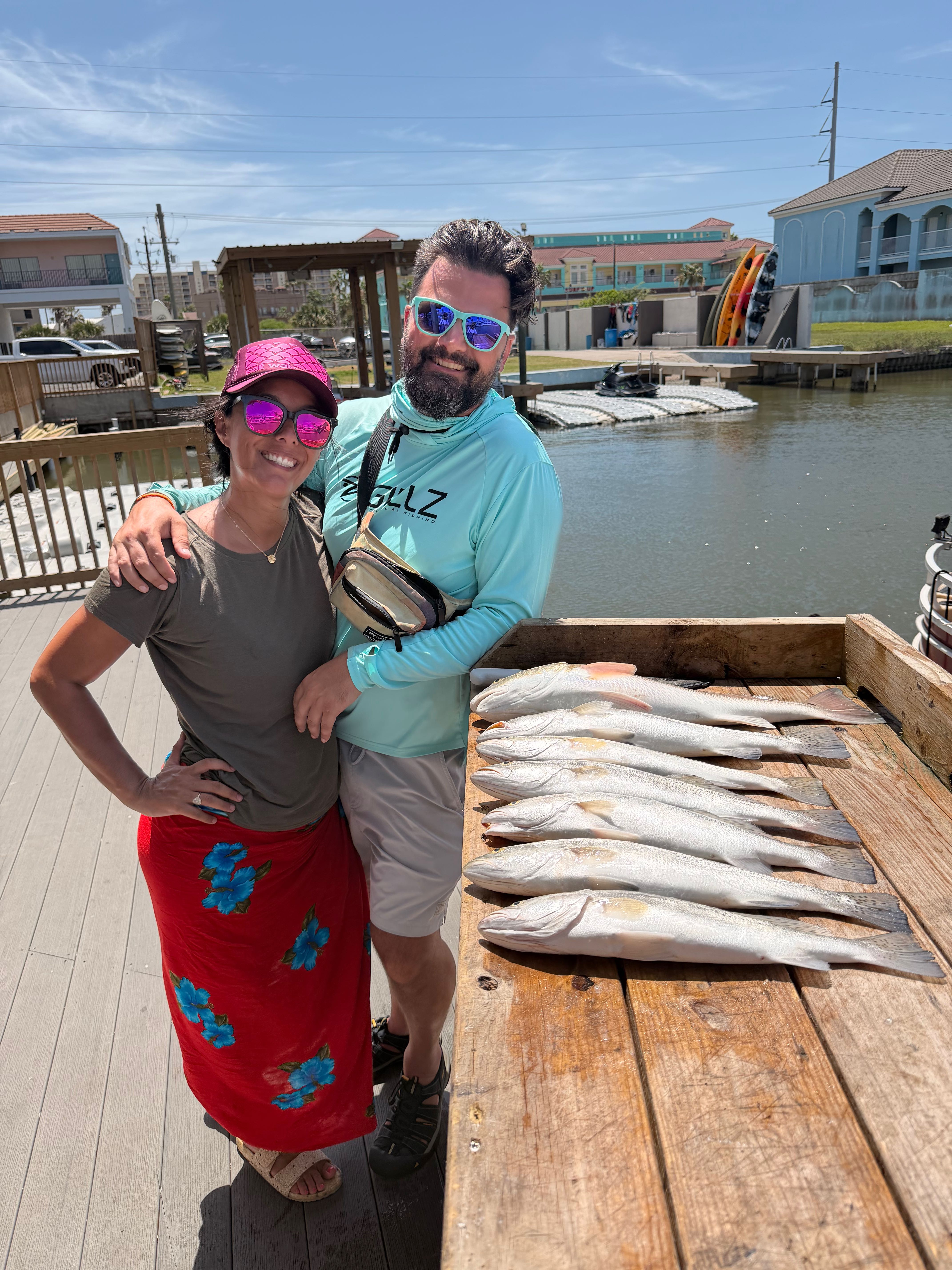 Successful fishing trip showing fresh caught speckled trout and redfish on wooden dock at South Padre Island TX