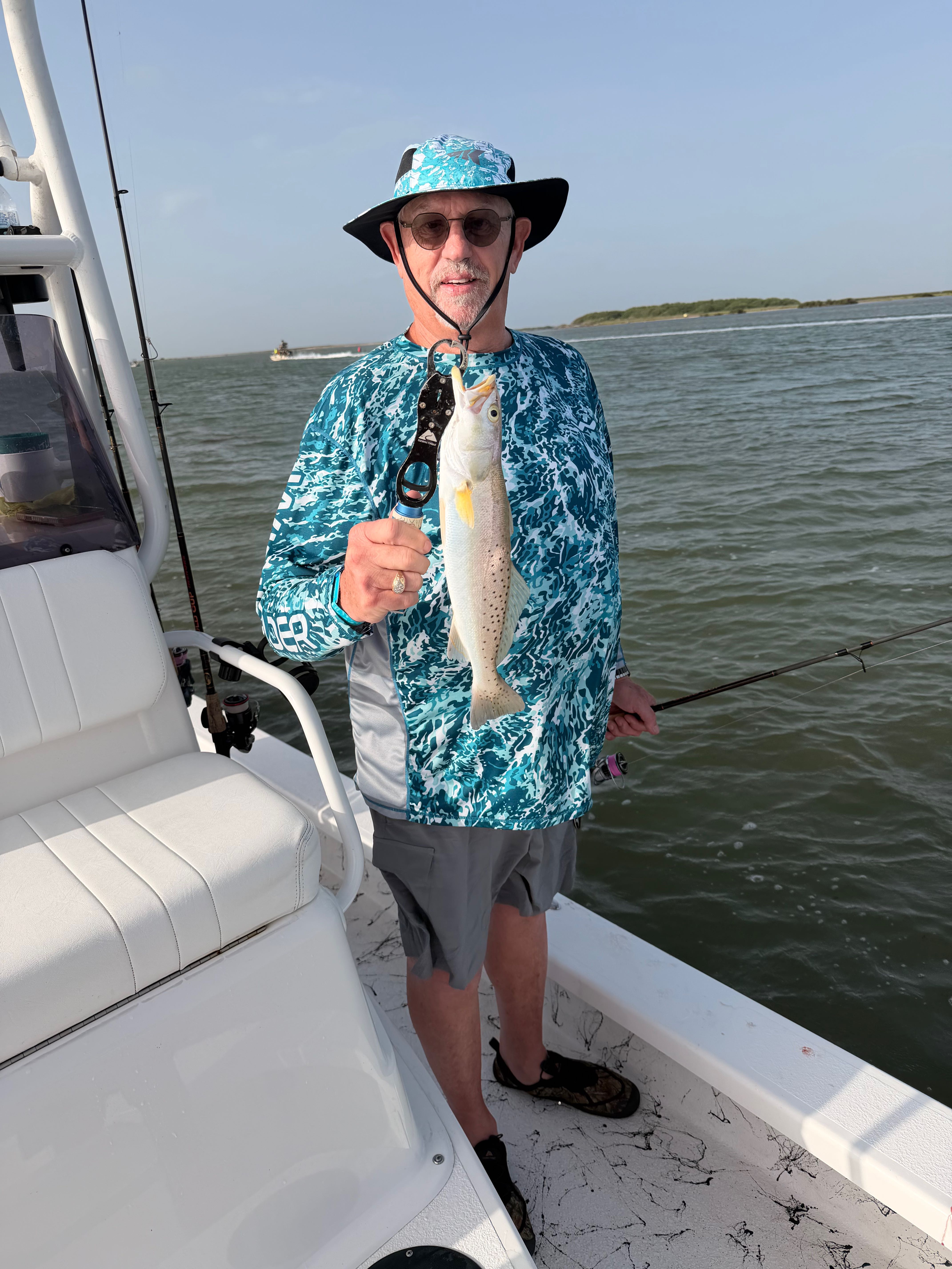 Two anglers displaying freshly caught speckled trout on fishing boat in South Padre Island TX waters
