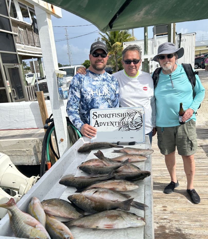 Successful fishing trip displaying multiple mutton snapper and other fish species on dock in Marathon FL