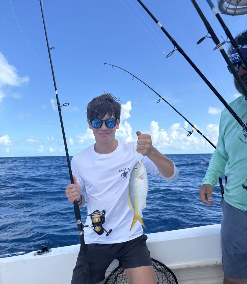 Yellowfin fish caught on fishing charter in Marathon FL with fishing rod and boat deck visible