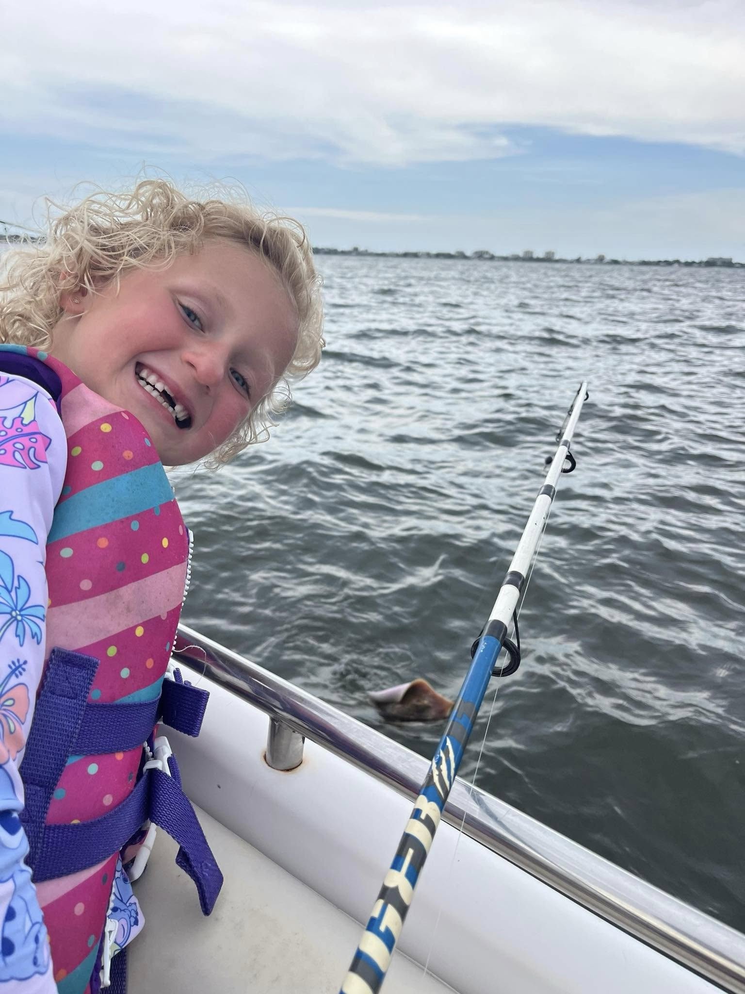 Fishing rod positioned on boat railing during fishing trip in Orange Beach AL waters