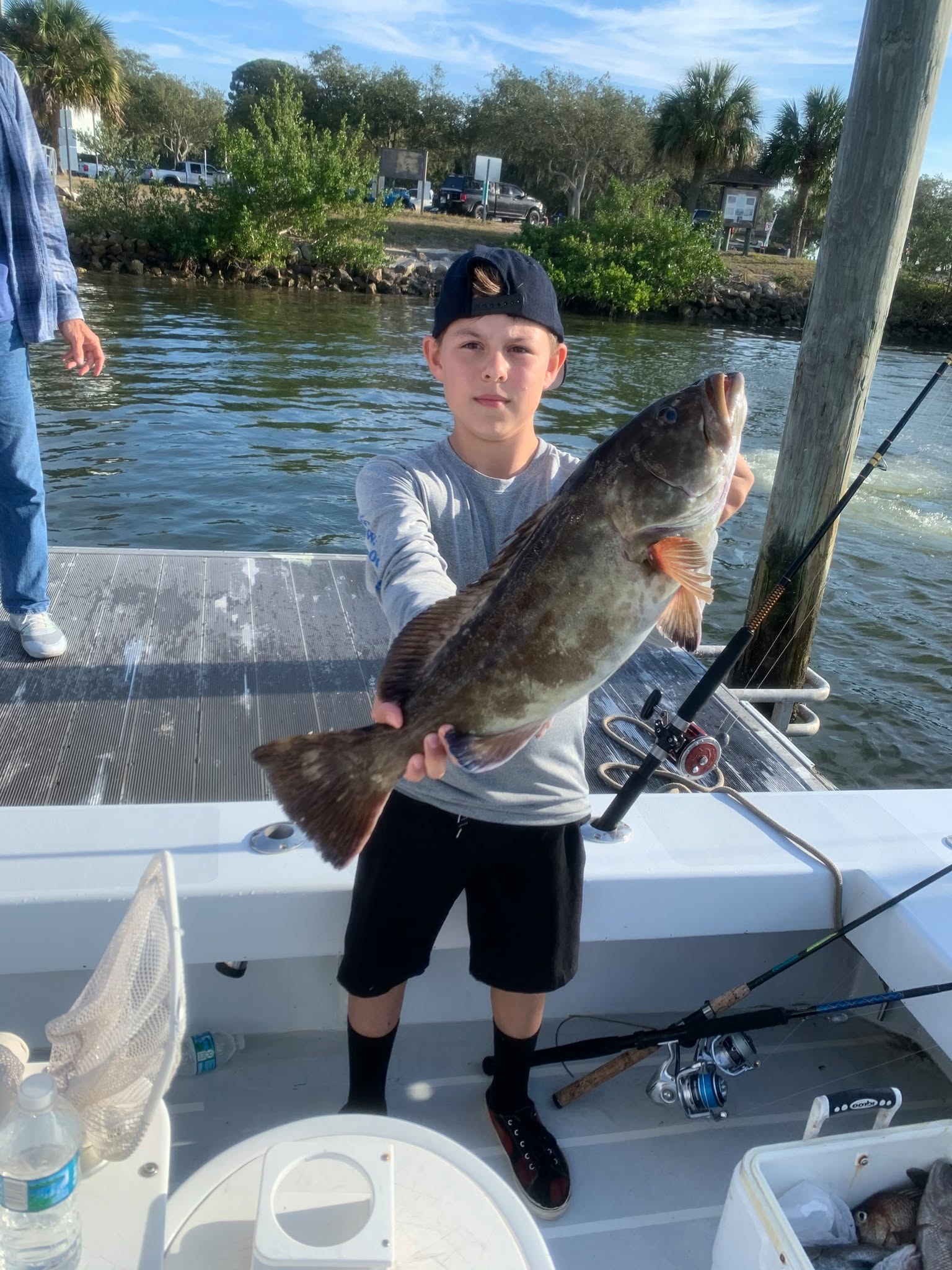 Kids learning saltwater fishing on 24ft bay boat in Clearwater shallow waters targeting trout