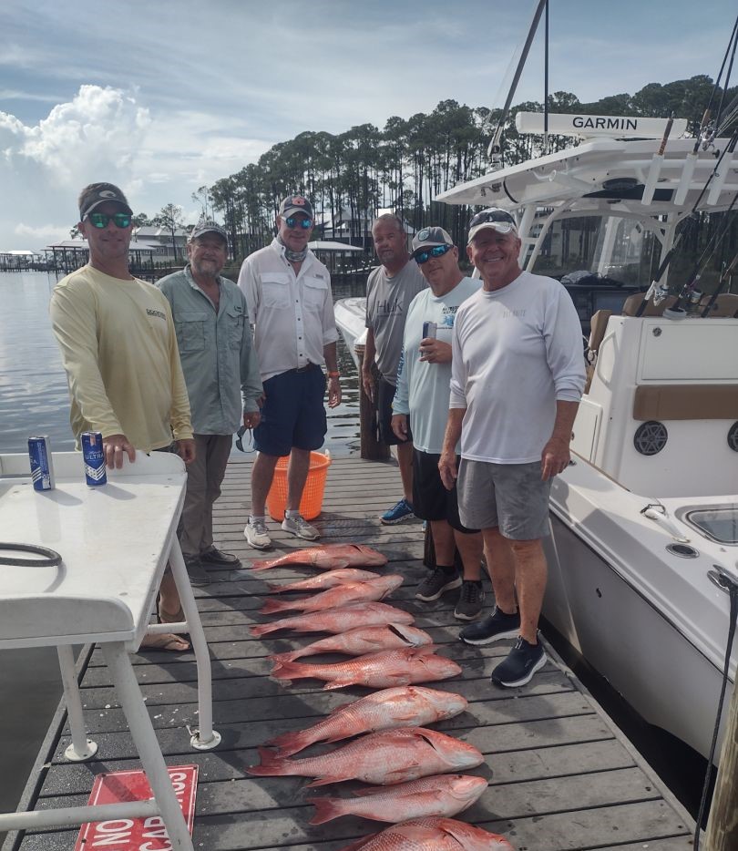 Successful red snapper fishing trip with multiple fish displayed on dock in Santa Rosa Beach FL