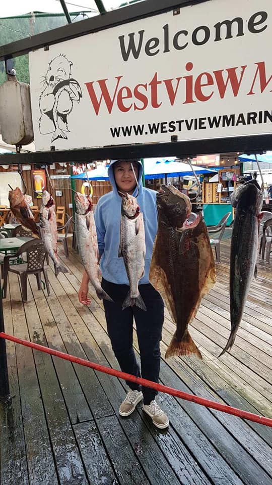 A fisherman holding a large great barracuda in Tahsis