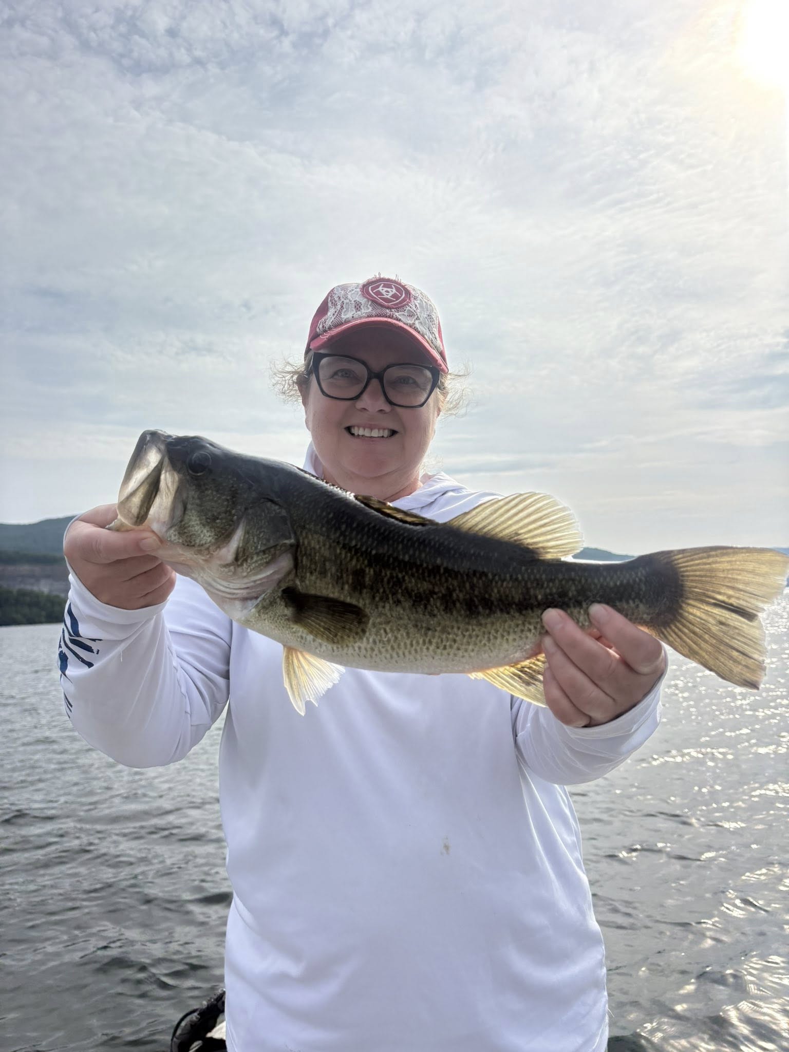 Angler holding freshly caught bass fish on lake in Chattanooga TN
