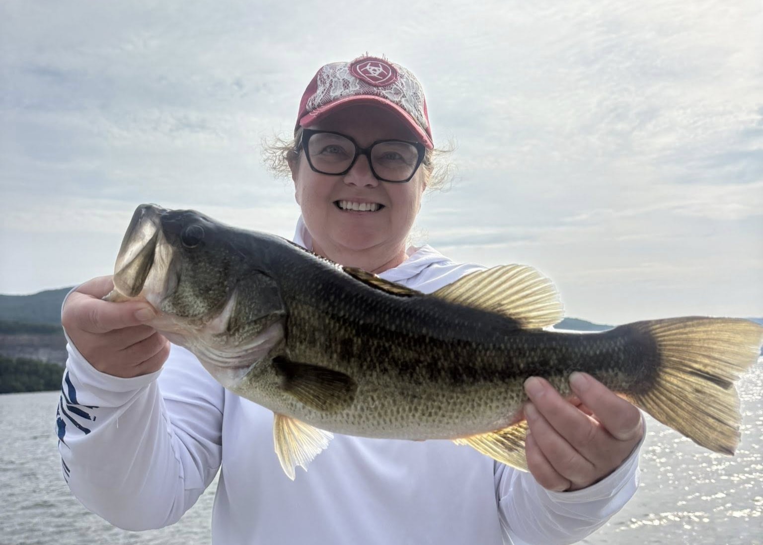 Angler holding large bass fish on lake in Chattanooga TN