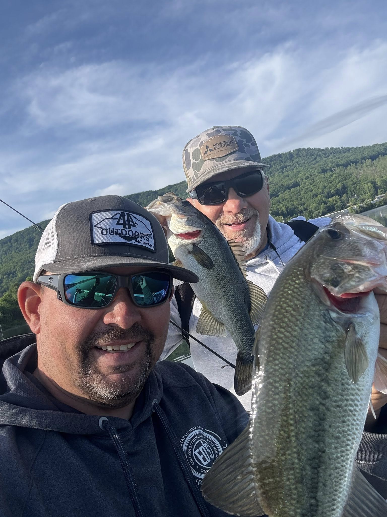 Two anglers holding freshly caught bass on fishing boat in Chattanooga TN