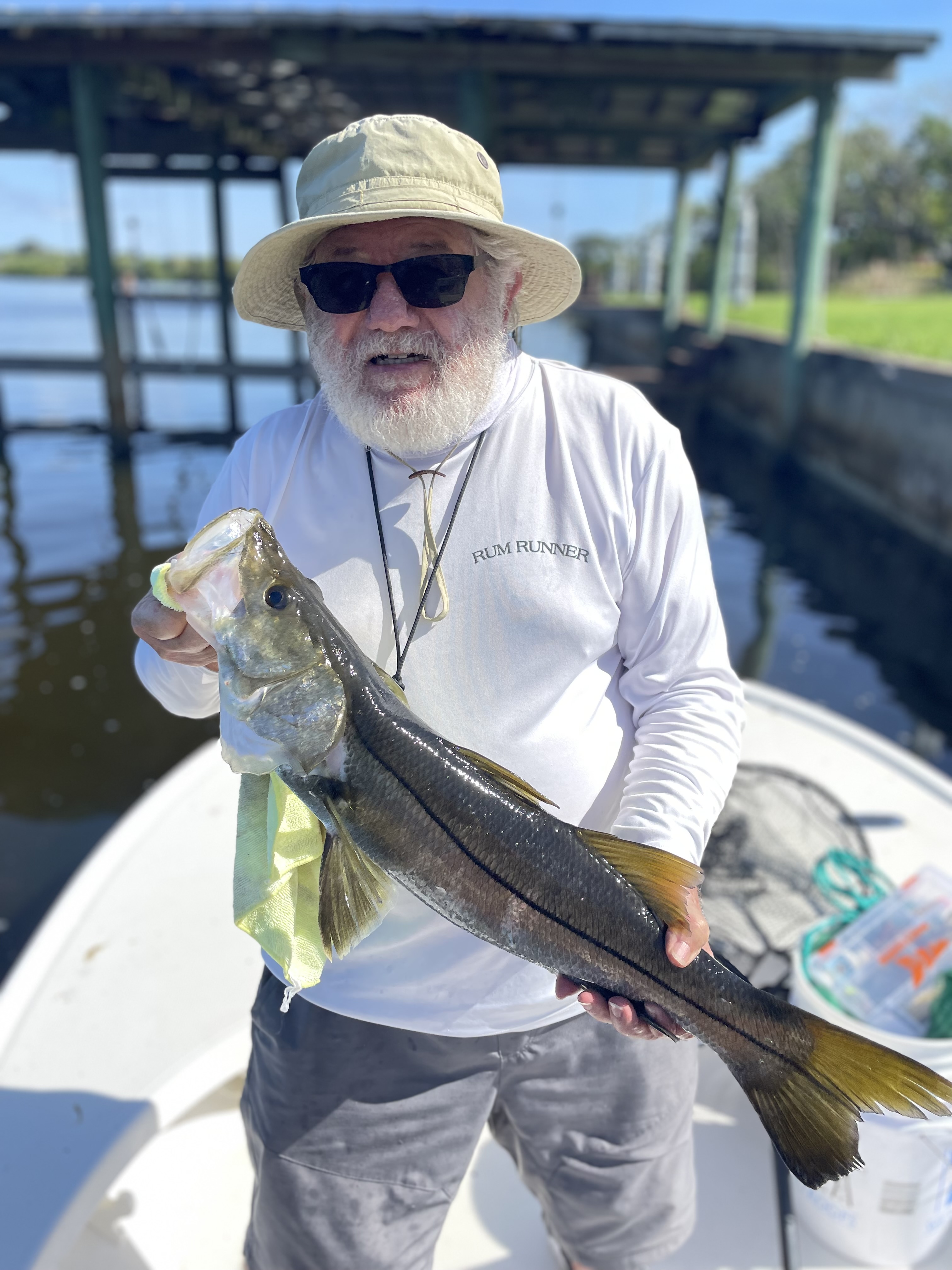 Angler holding caught snook fish on fishing boat in Palm Bay FL