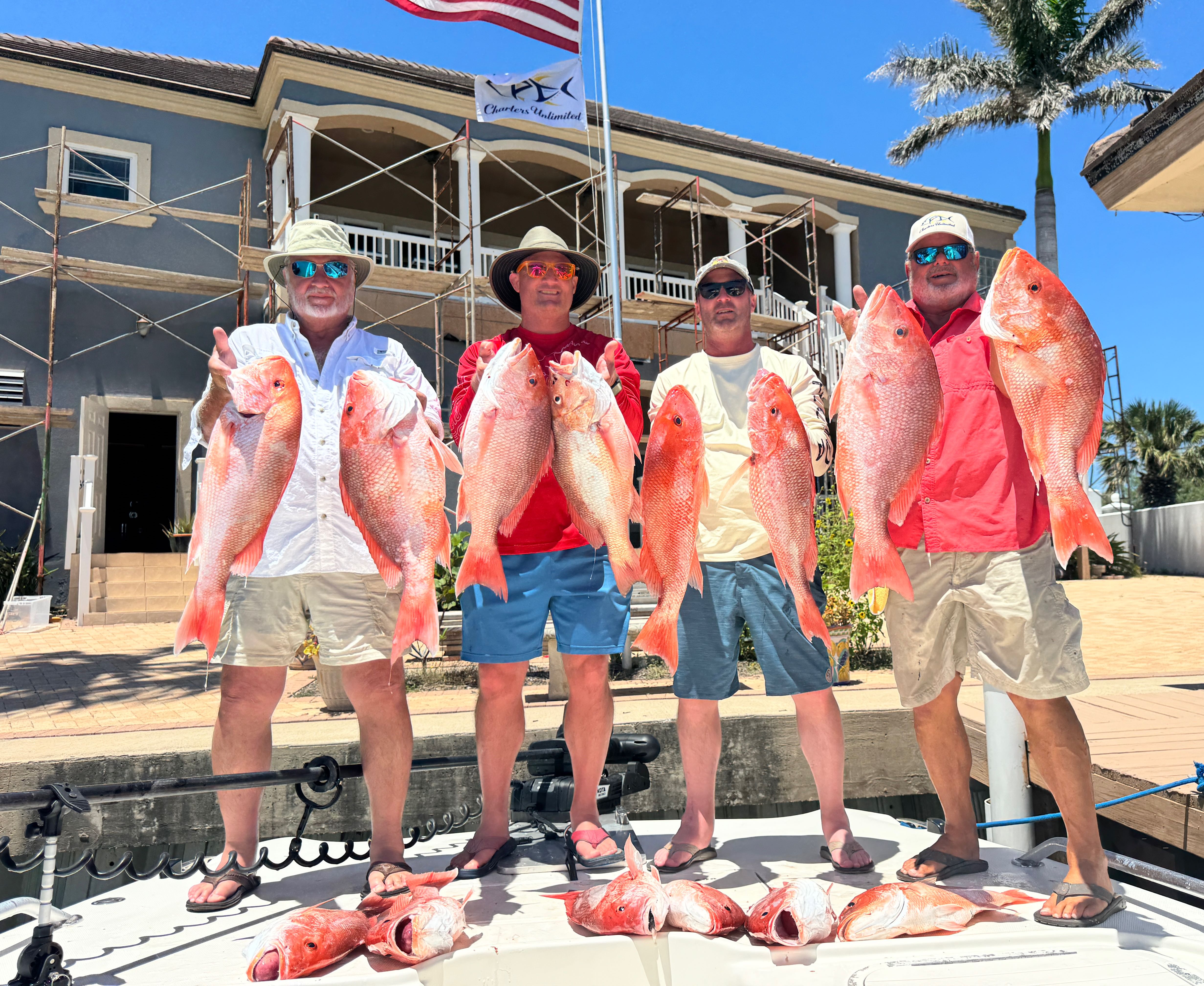 Four anglers displaying red snapper catch at Port Isabel TX fishing dock