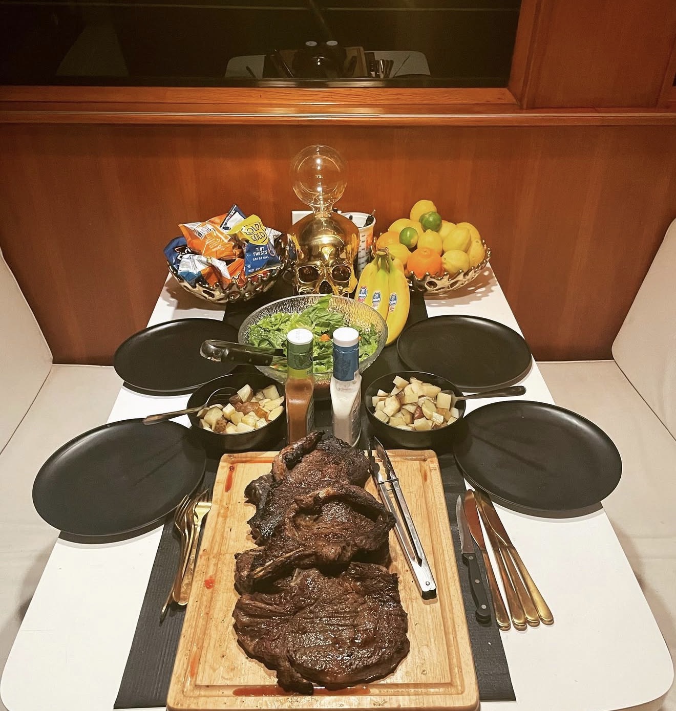 Grilled steaks and fresh salad prepared on fishing cruise dining table in San Diego CA