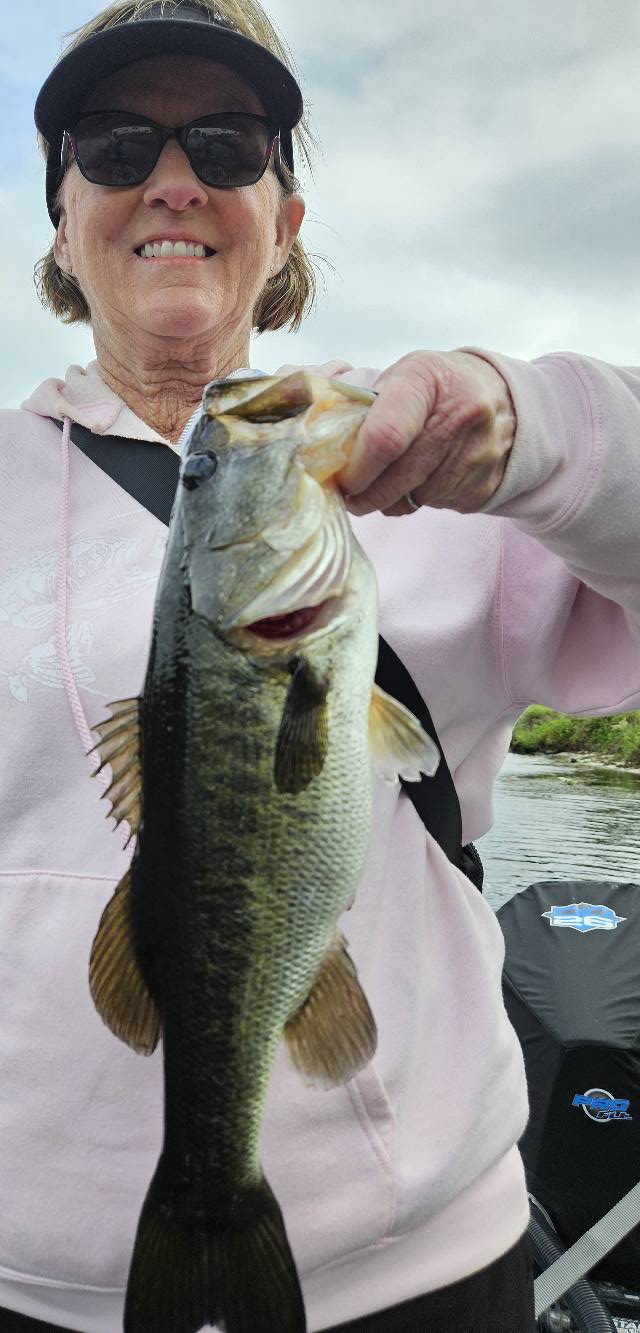 Angler holding freshly caught bass while fishing in South Bay FL