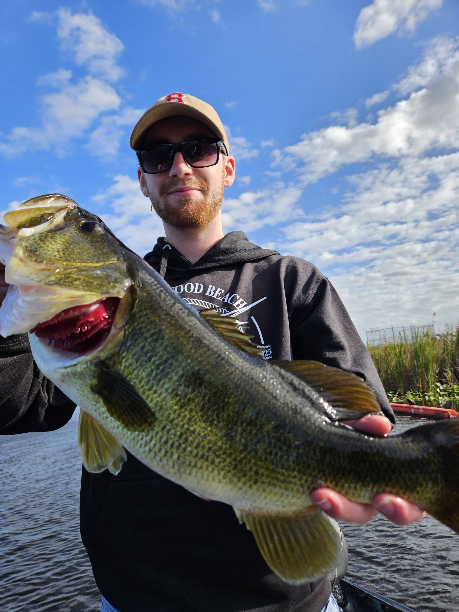 Large bass fish being held after successful catch in South Bay FL fishing trip