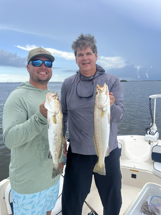Two people fishing in an unknown location
