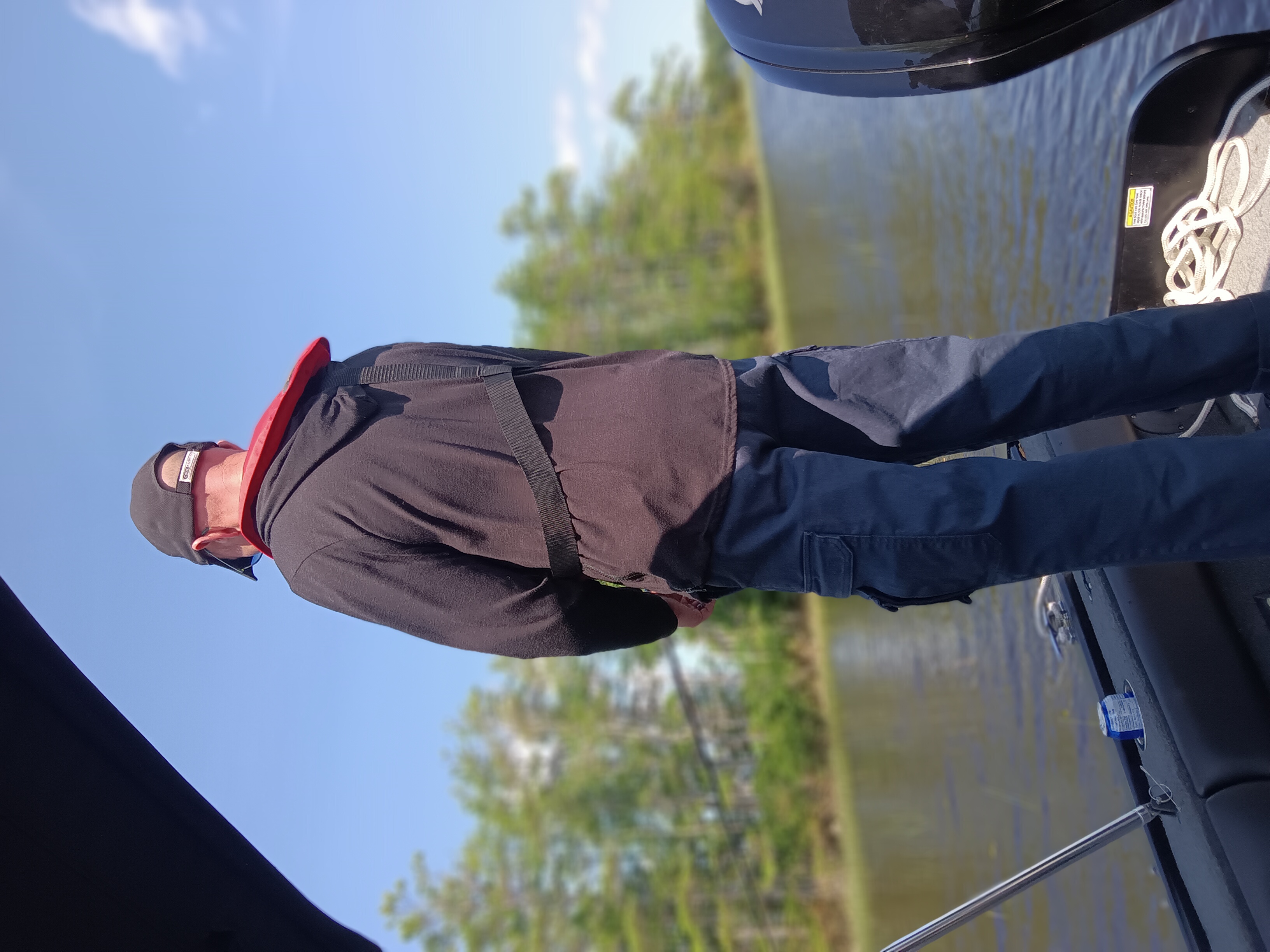 Angler on fishing boat deck with rod and equipment ready for fishing trip