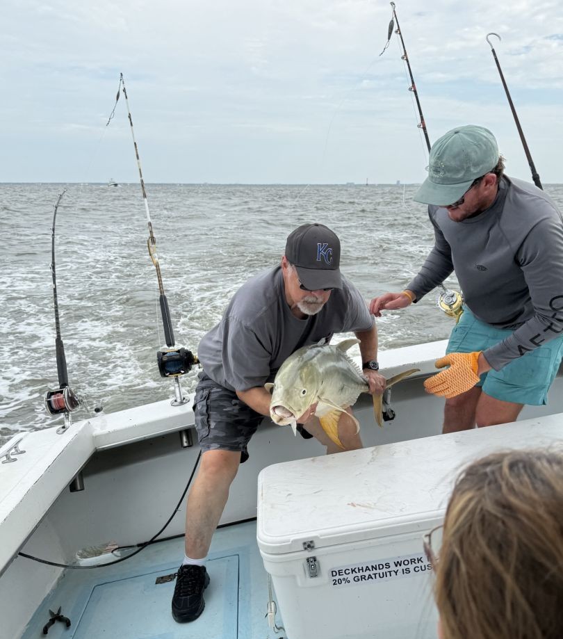 Fishing charter boat in Biloxi MS with large fish being handled on deck