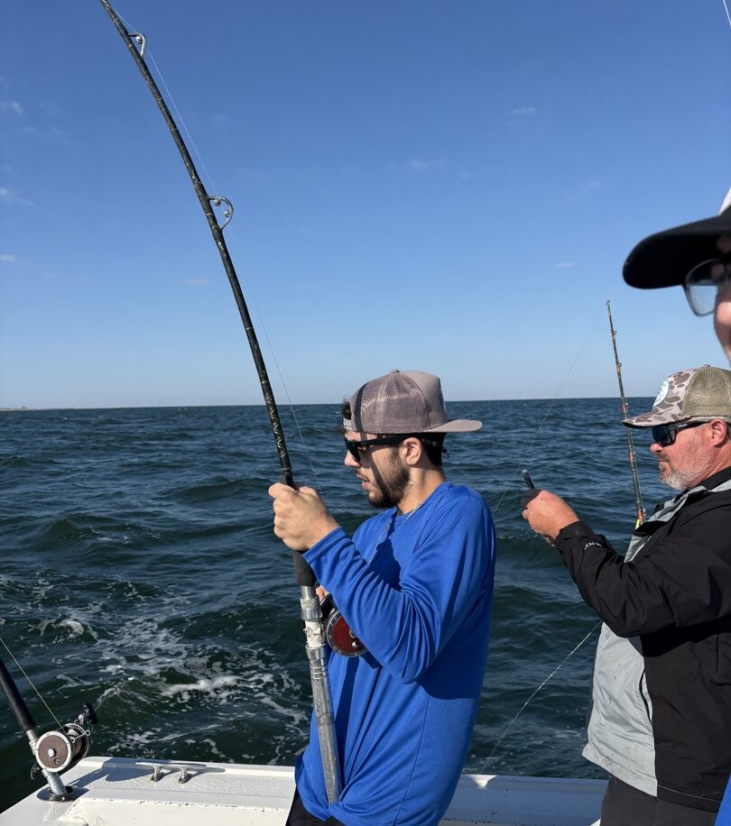 Deep sea fishing from boat in Biloxi MS with fishing rods extended over ocean water