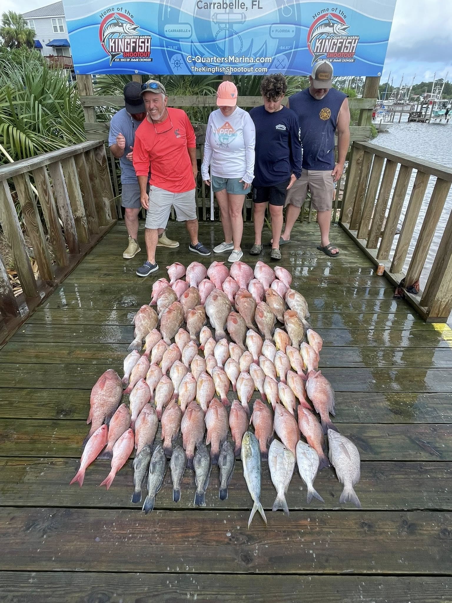 Large catch of mixed fish species displayed on wooden dock in Carrabelle FL after successful fishing trip