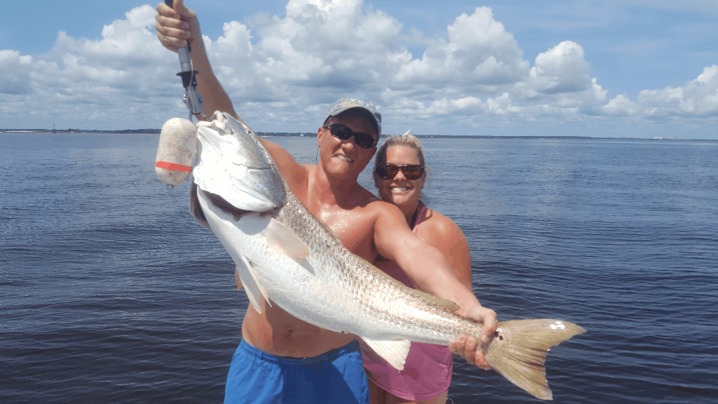 A fisherman and their companion enjoying a fishing tour in Fernandina Beach