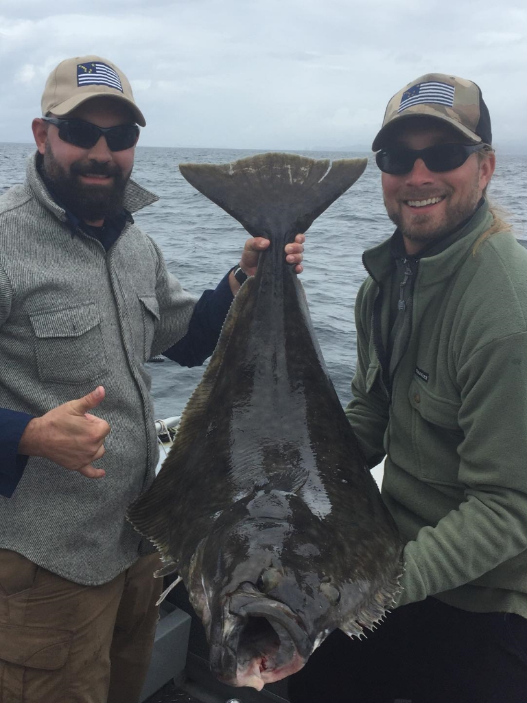 A fisherman holds a large Pacific Halibut in Ketchikan