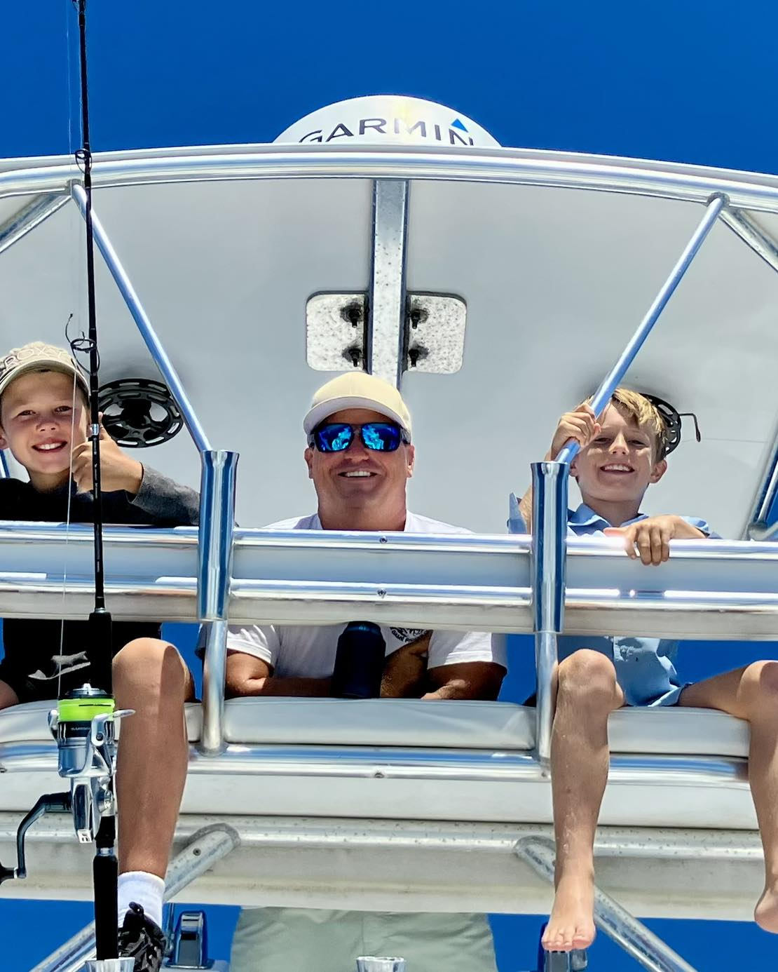 Three people enjoying a fishing trip at the ocean