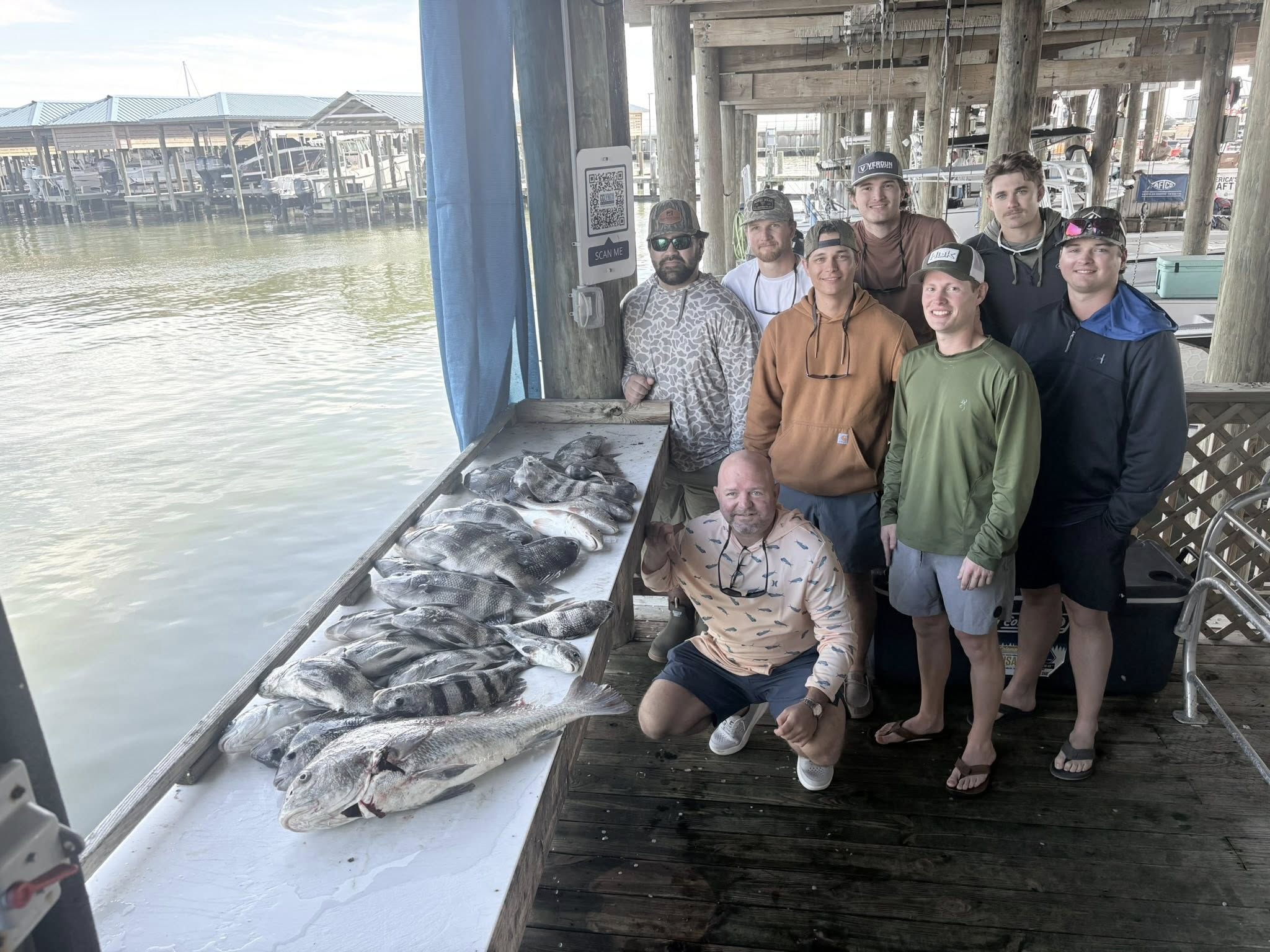 Fishing group with large black drum catch displayed on cleaning table at Bay St. Louis MS marina