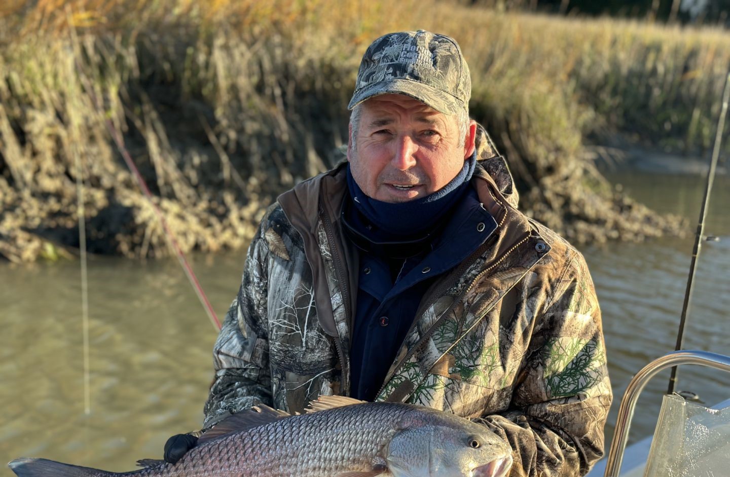 Angler holding caught redfish on boat in Darien GA waters