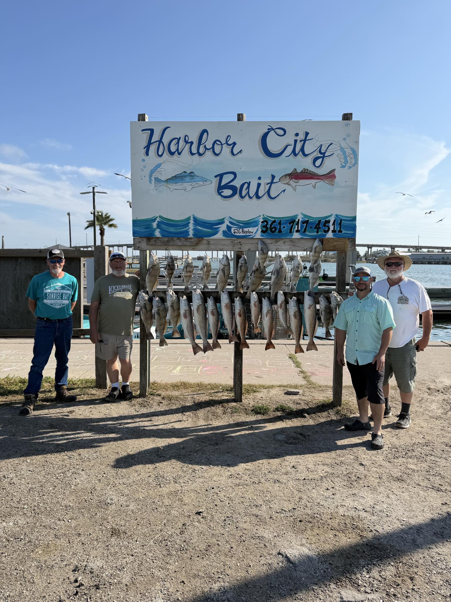 Successful fishing charter displaying multiple redfish catch at Harbor City Bait in Rockport TX