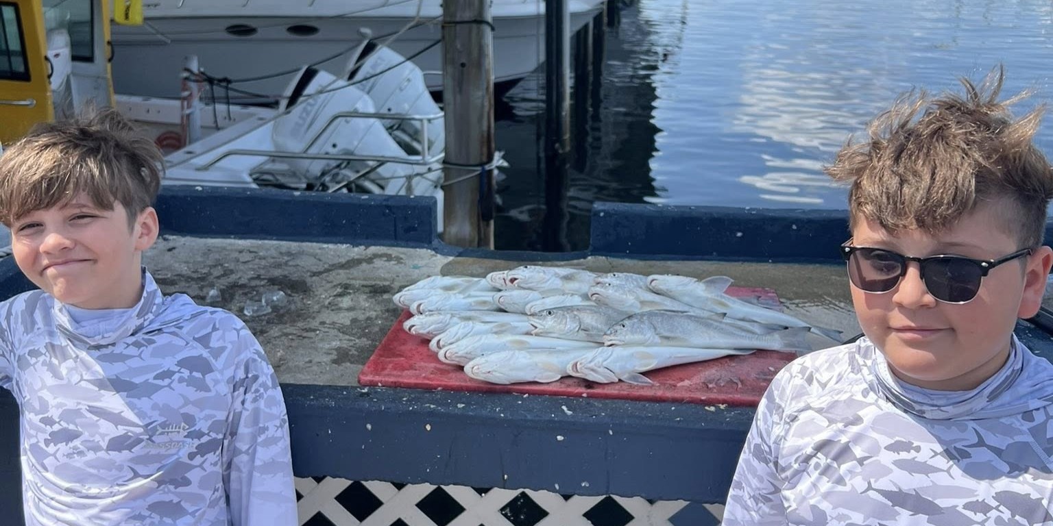Kids fishing charter boat in Tarpon Springs inshore waters with family-friendly setup