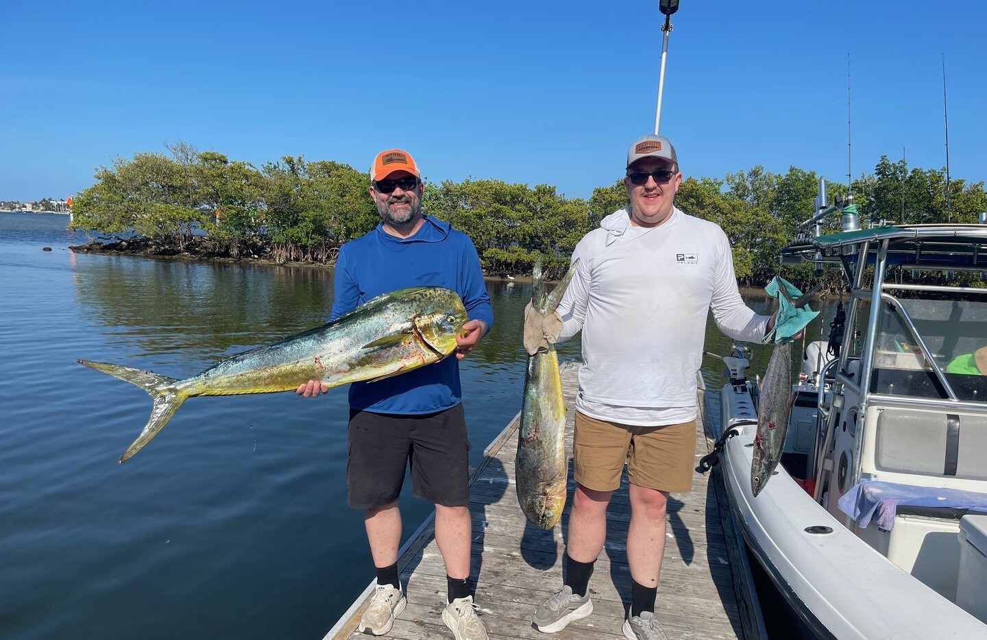 Successful fishing charter displaying fresh caught mahi mahi and king mackerel on dock in Lantana FL