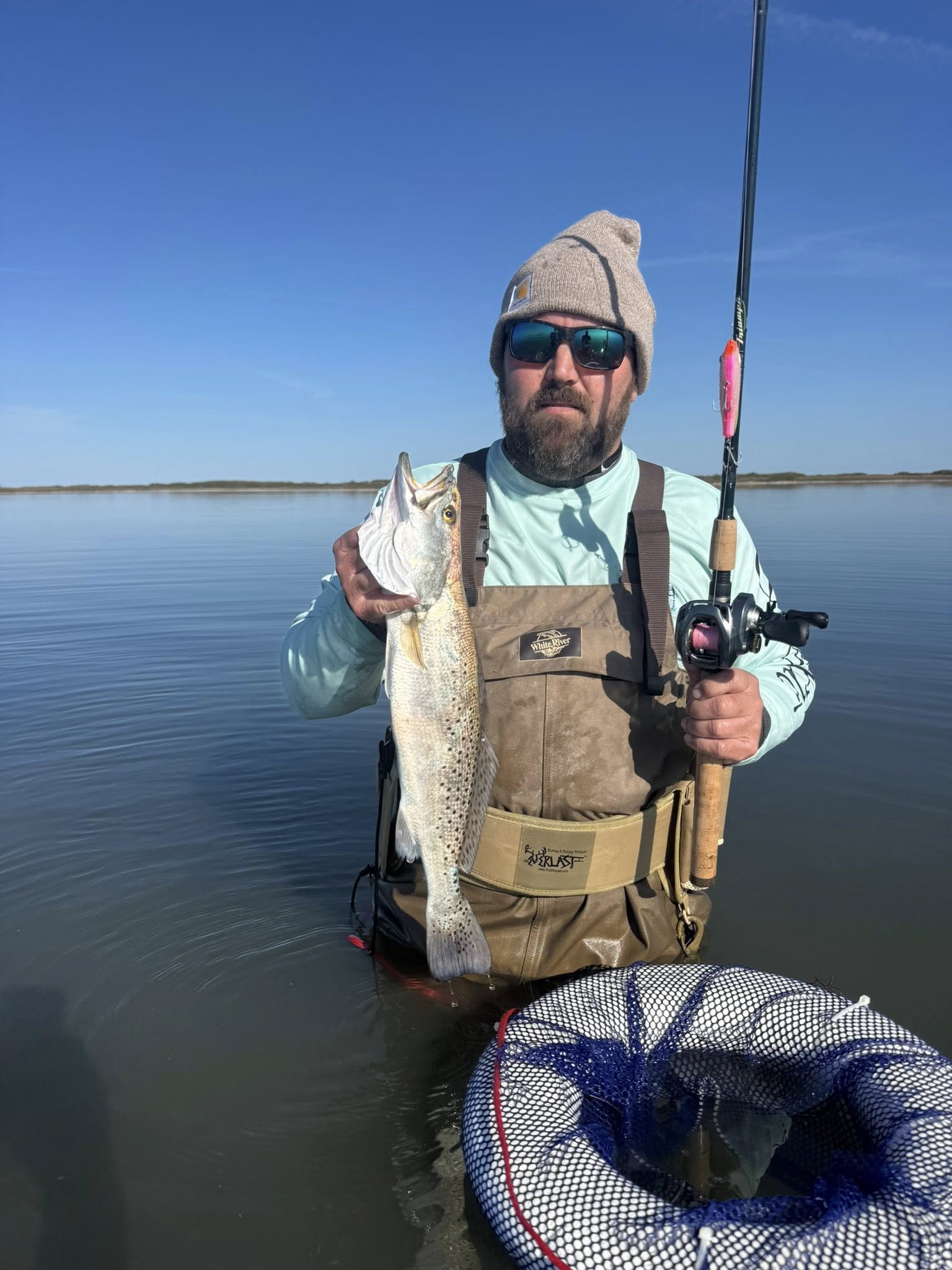 Speckled trout fishing catch in Corpus Christi TX with fishing rod and net