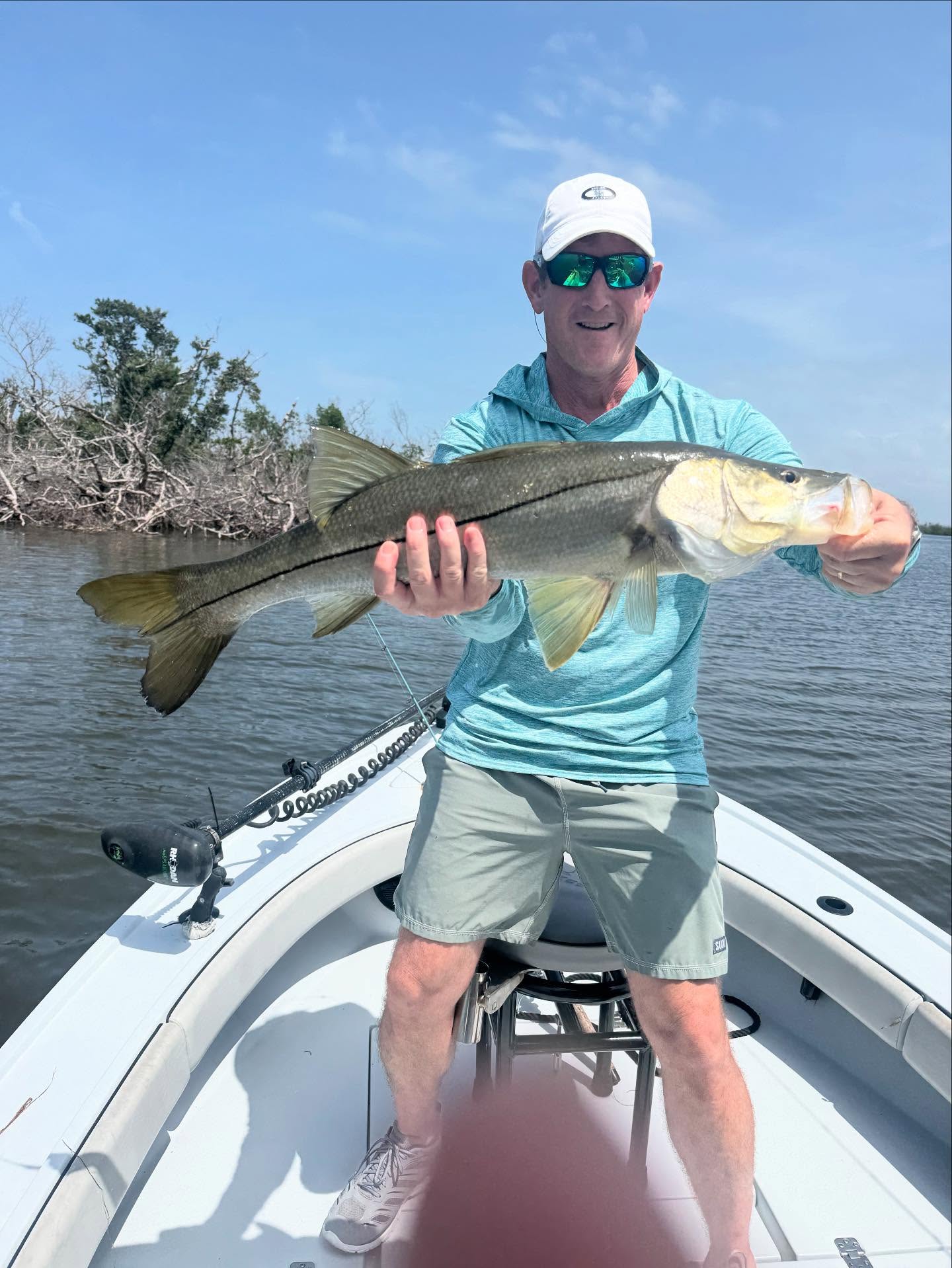 Angler holding caught snook on fishing boat in Placida FL waters