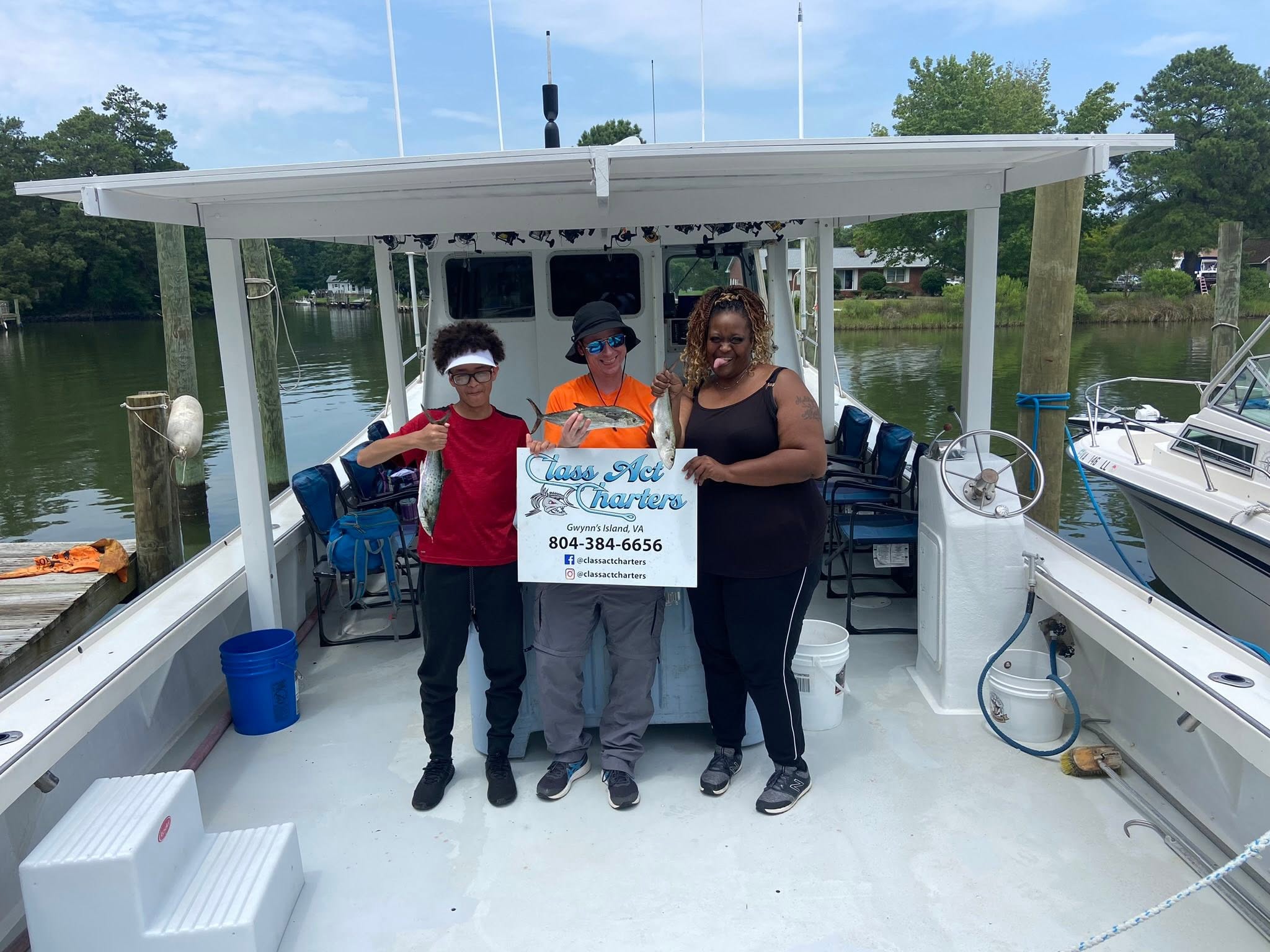 Charter fishing boat with passengers holding business sign at Gwynn Island VA marina