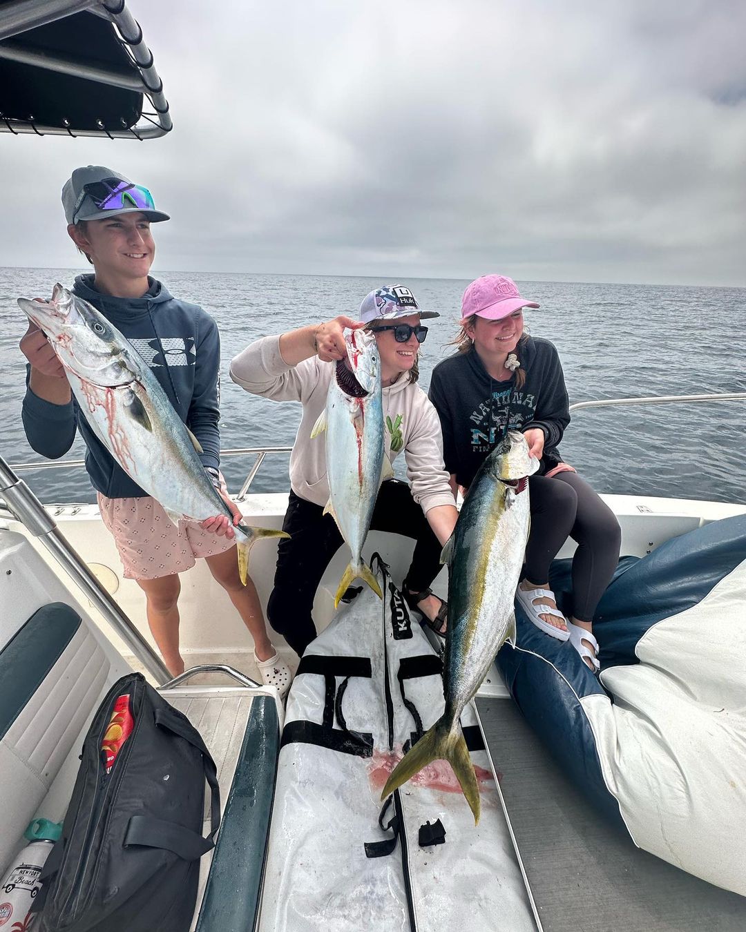 Three people fishing on the coast of CA
