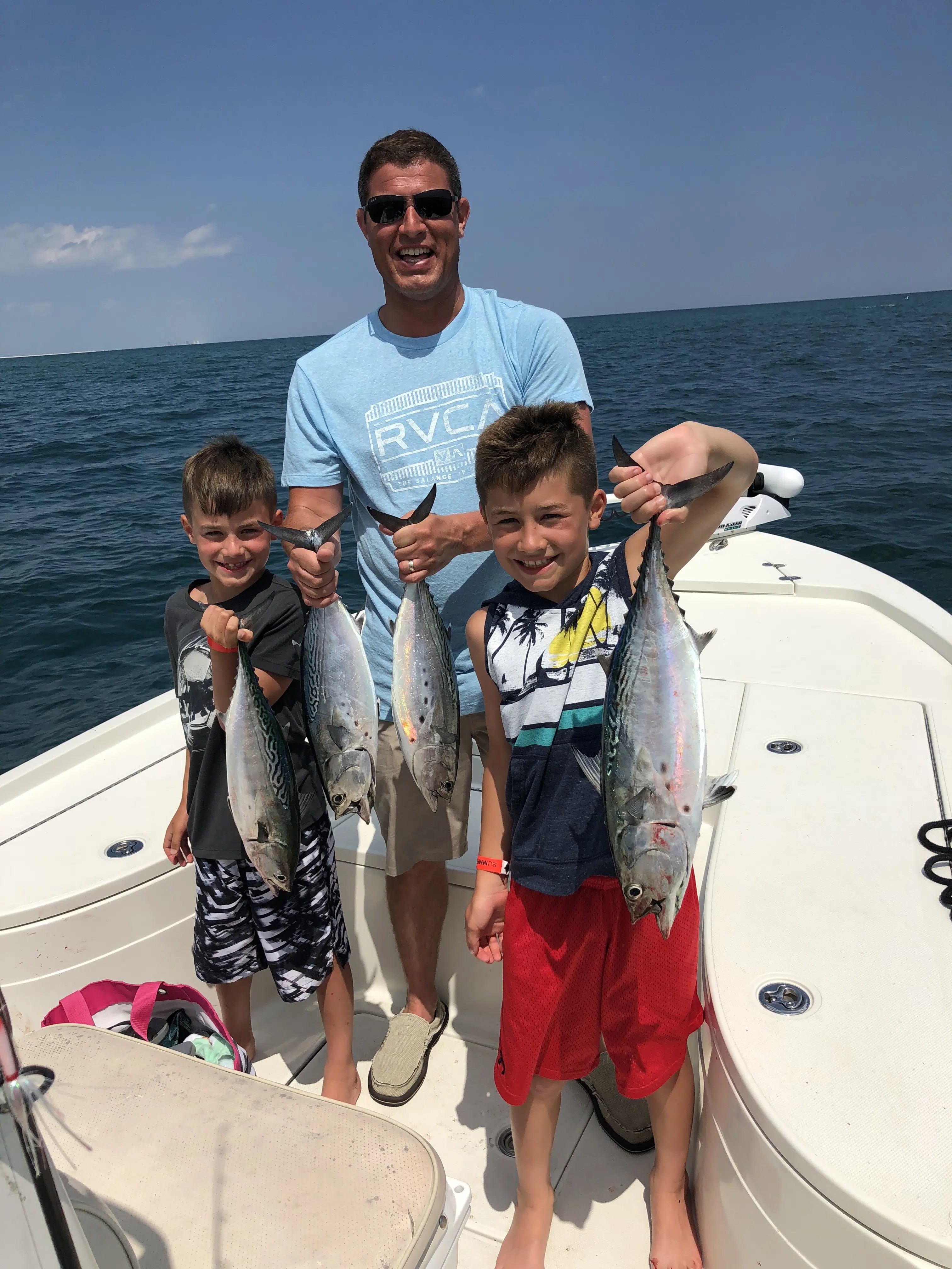 Four little tunny and one atlantic bonito fish caught by three people at Pensacola Beach