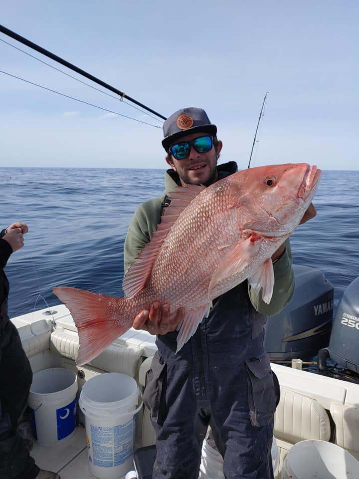 A fisherman holding a large mutton snapper in South Carolina