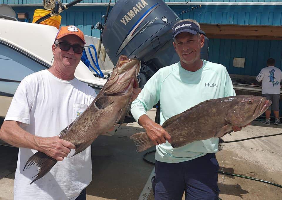 Two anglers holding two large fish caught in SC