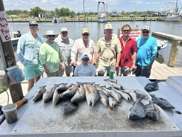 Successful redfish fishing trip in Barataria LA with large catch displayed on dock