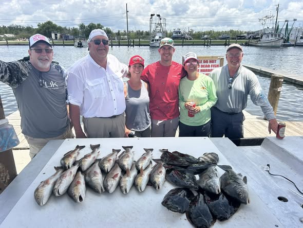Successful redfish fishing trip in Barataria LA with fresh catch displayed on cleaning table at marina