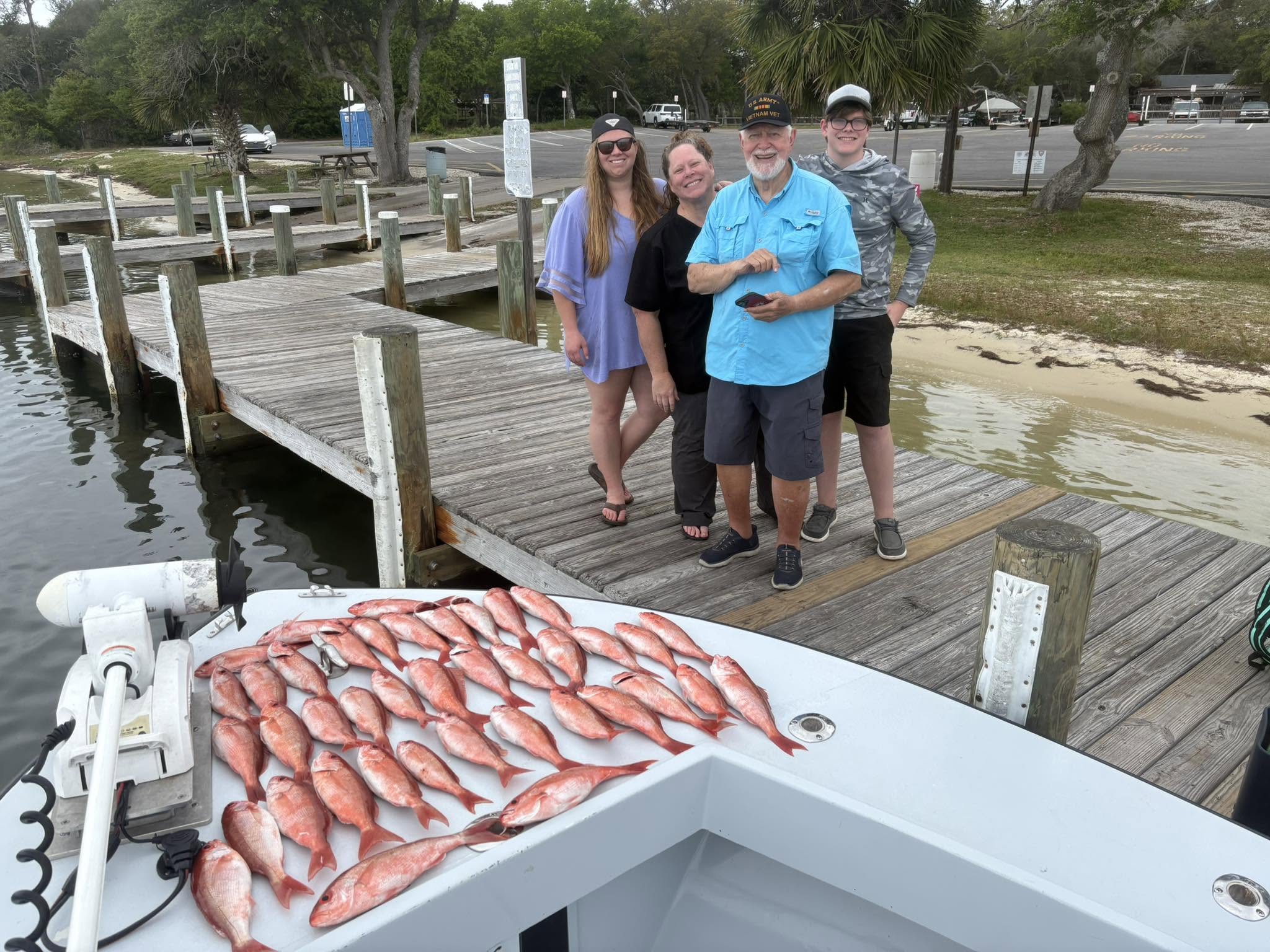 Successful fishing trip in Pensacola FL with large catch of red snapper displayed on boat deck at marina