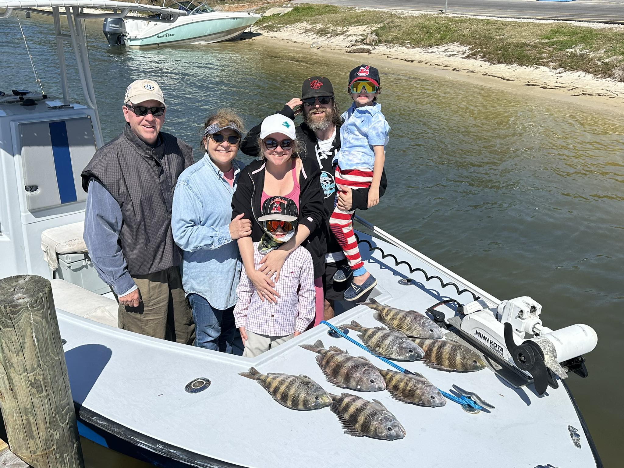 Family fishing trip displaying fresh caught sheepshead on boat deck in Pensacola FL